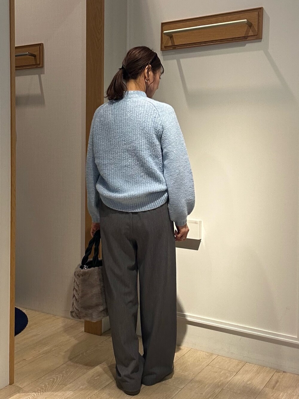 ブルー系のニット/セーターを着用したレディースの冬コーディネートの2枚目の写真