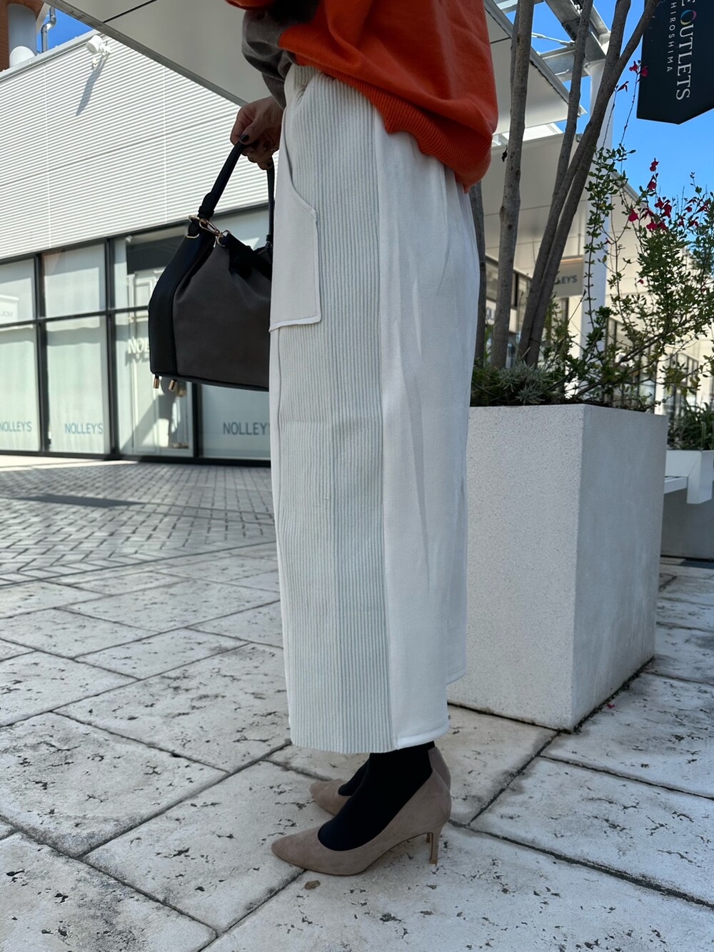 ブラウン系のニット/セーター、グレー系のスカート、ブラウン系のブルゾンを着用したレディースの秋コーディネートの9枚目の写真