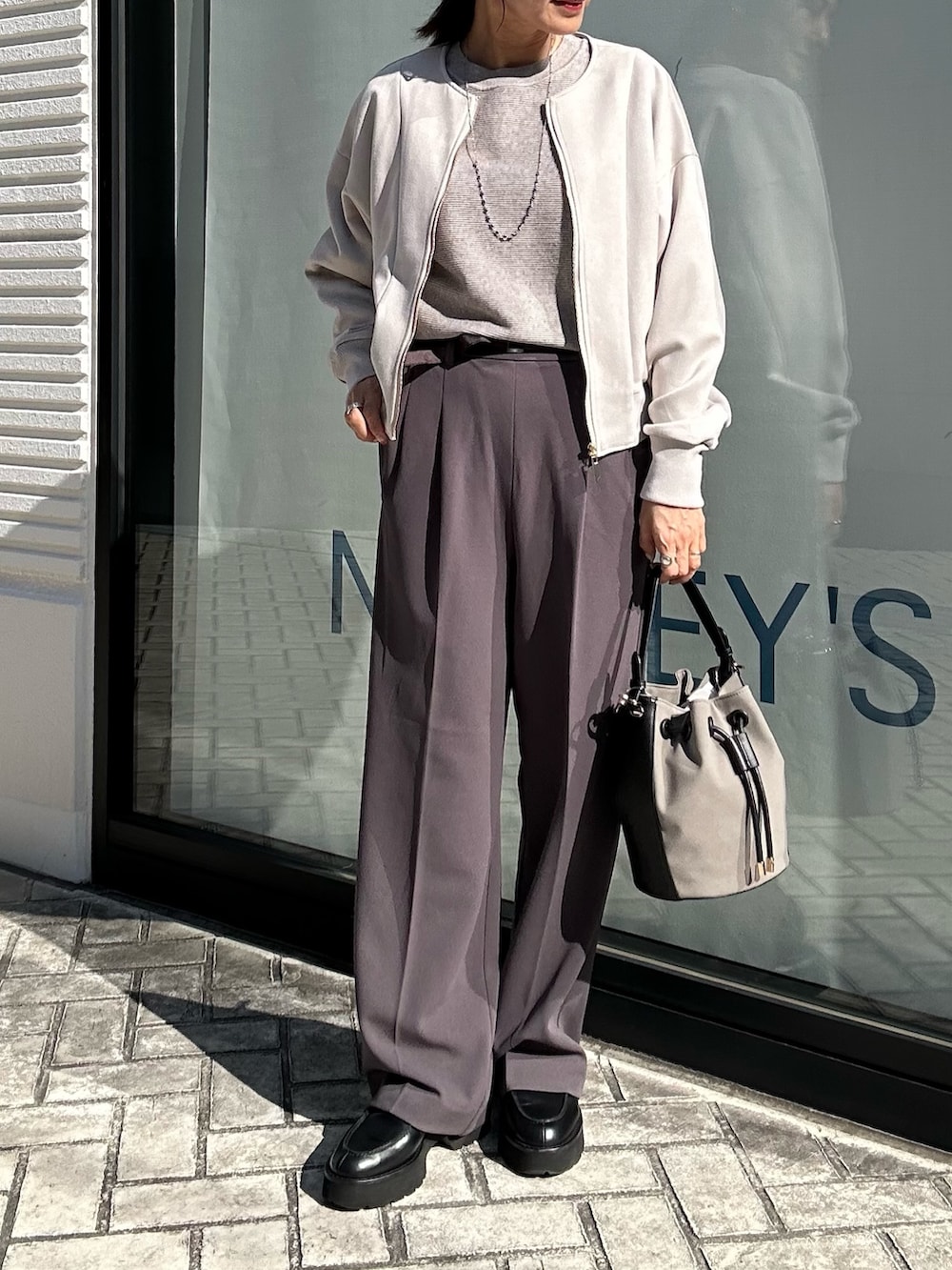 グレー系のその他パンツ、グレー系のニット/セーター、ベージュ系のブルゾンを着用したレディースの秋コーディネートの8枚目の写真