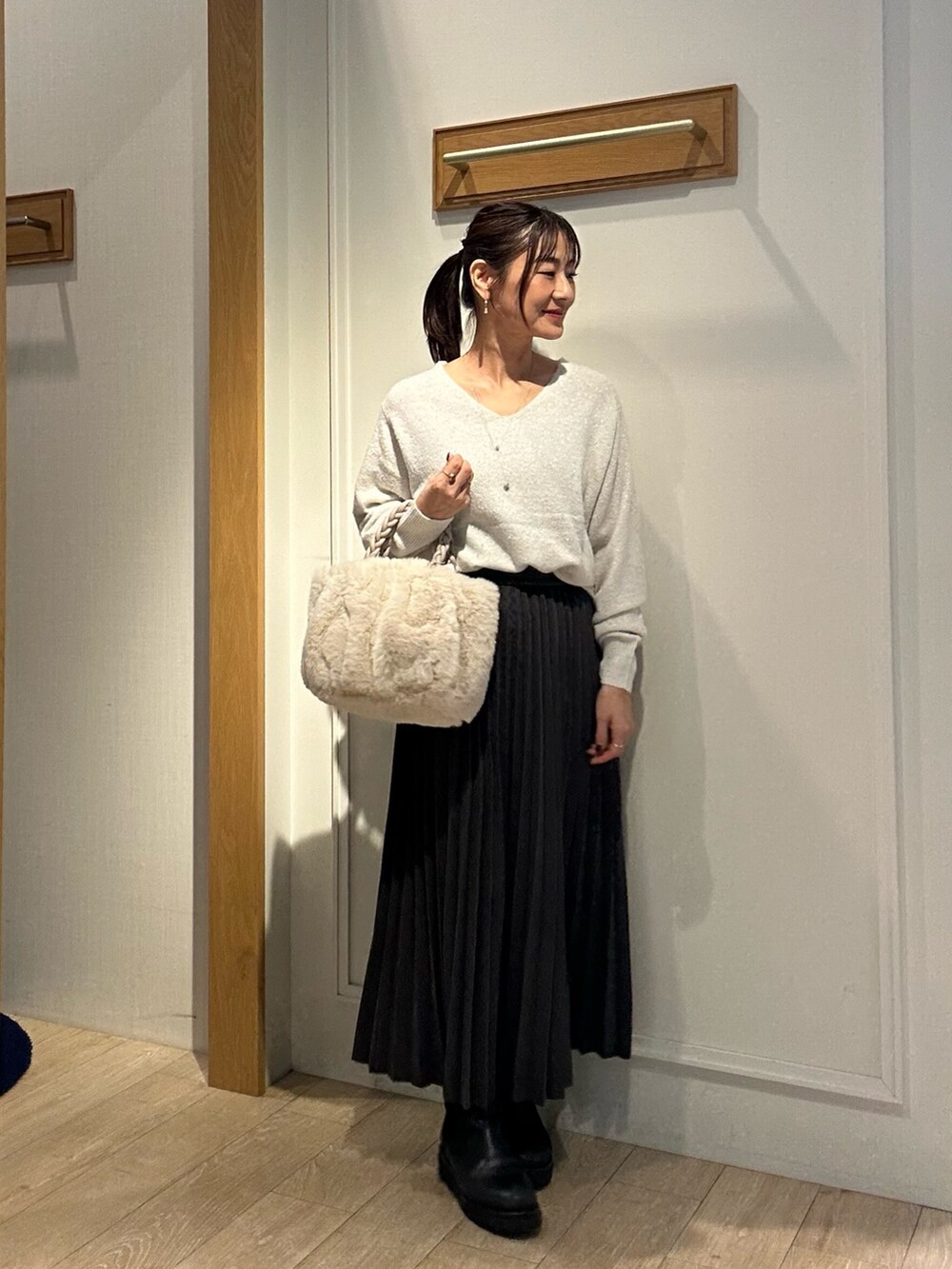 ホワイト系のニット/セーター、グレー系のスカート、ホワイト系のトートバッグを着用したレディースの秋コーディネートの8枚目の写真