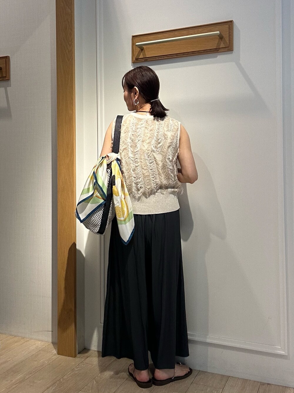 ベージュ系のニット/セーター、グレー系のその他パンツ、グレー系のショルダーバッグを着用したレディースの夏コーディネートの7枚目の写真