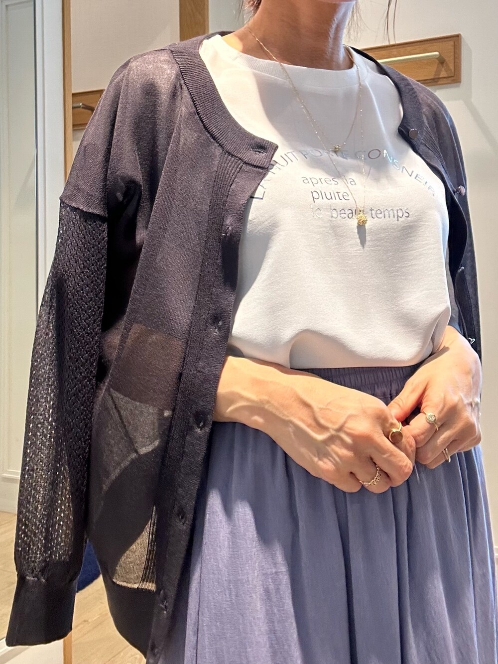 パープル系のスカート、ホワイト系のシャツ/ブラウス、グレー系のカーディガン/ボレロを着用したレディースの夏コーディネートの9枚目の写真