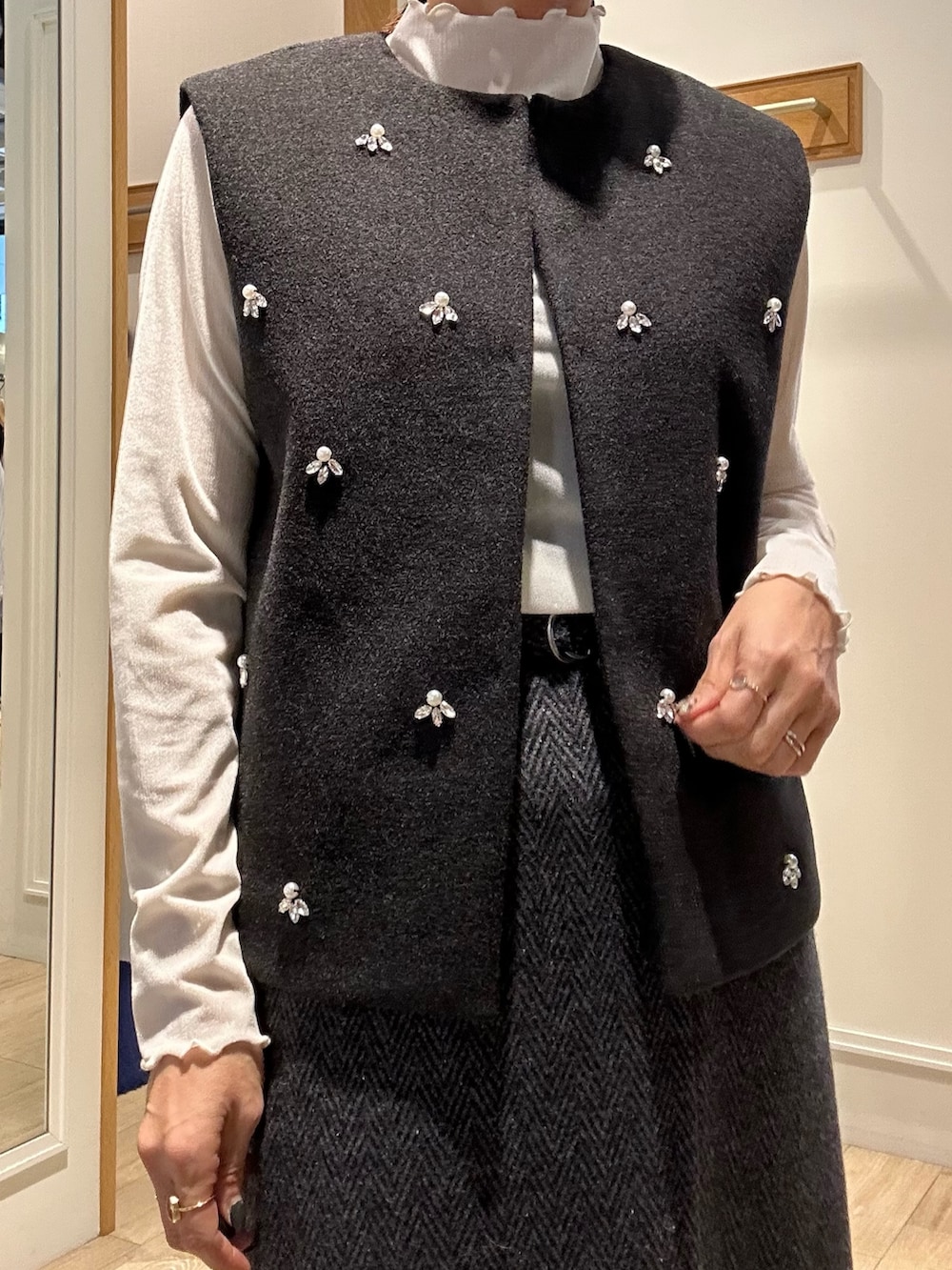 グレー系のブルゾン、ホワイト系のTシャツ/カットソー、グレー系のスカートを着用したレディースの秋コーディネートの6枚目の写真