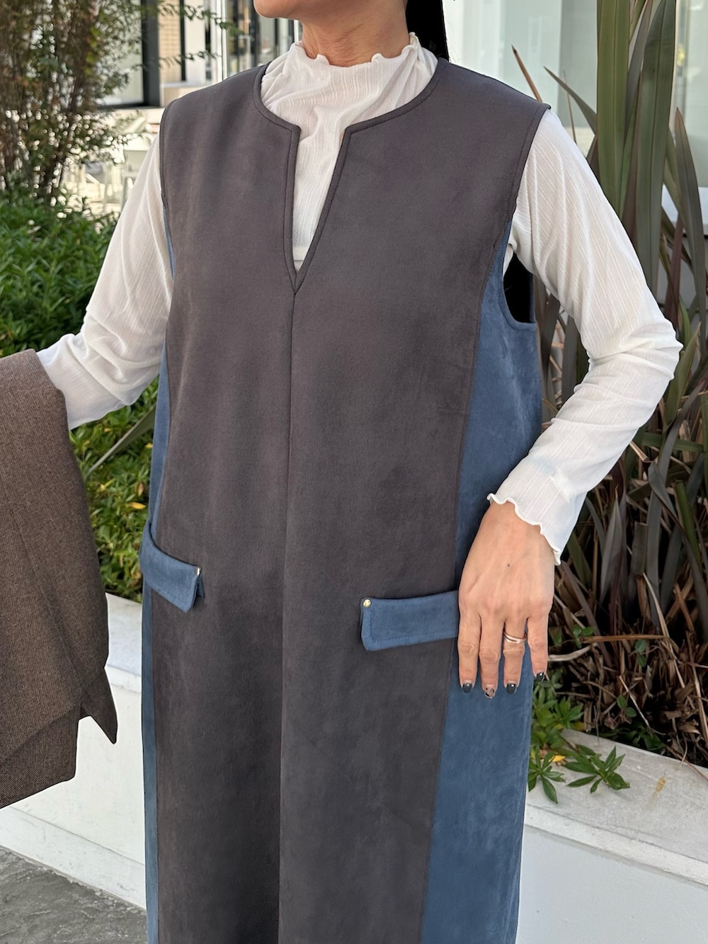 グレー系のワンピース、ホワイト系のTシャツ/カットソー、ブラウン系のテーラードジャケットを着用したレディースの秋コーディネートの3枚目の写真