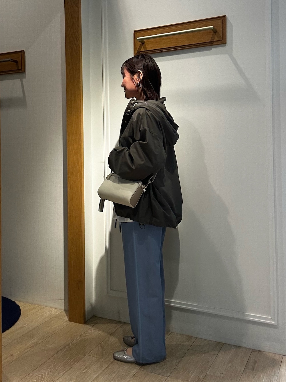 グリーン系のブルゾン、ホワイト系のシャツ/ブラウス、ブルー系のデニムパンツを着用したレディースの冬コーディネートの2枚目の写真