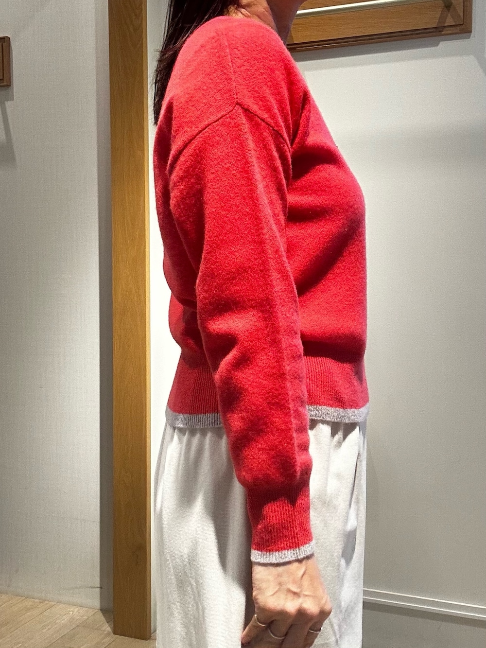 ピンク系のニット/セーター、ホワイト系のスカート、グレー系のダウンジャケット/コートを着用したレディースの冬コーディネートの5枚目の写真