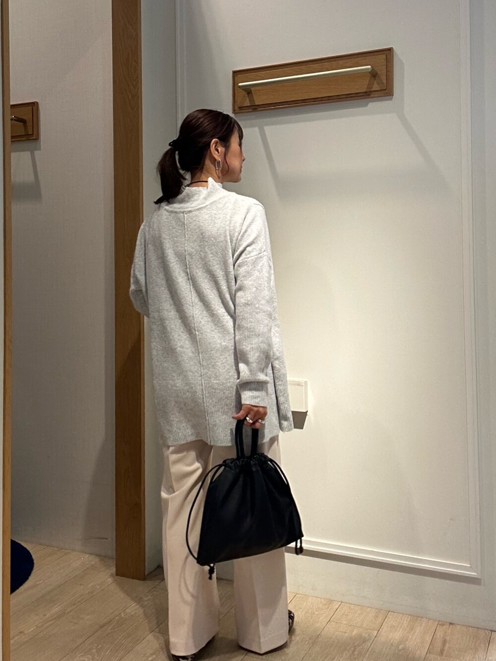 グレー系のニット/セーター、ホワイト系のその他パンツ、ブラック系のショルダーバッグを着用したレディースの冬コーディネートの3枚目の写真