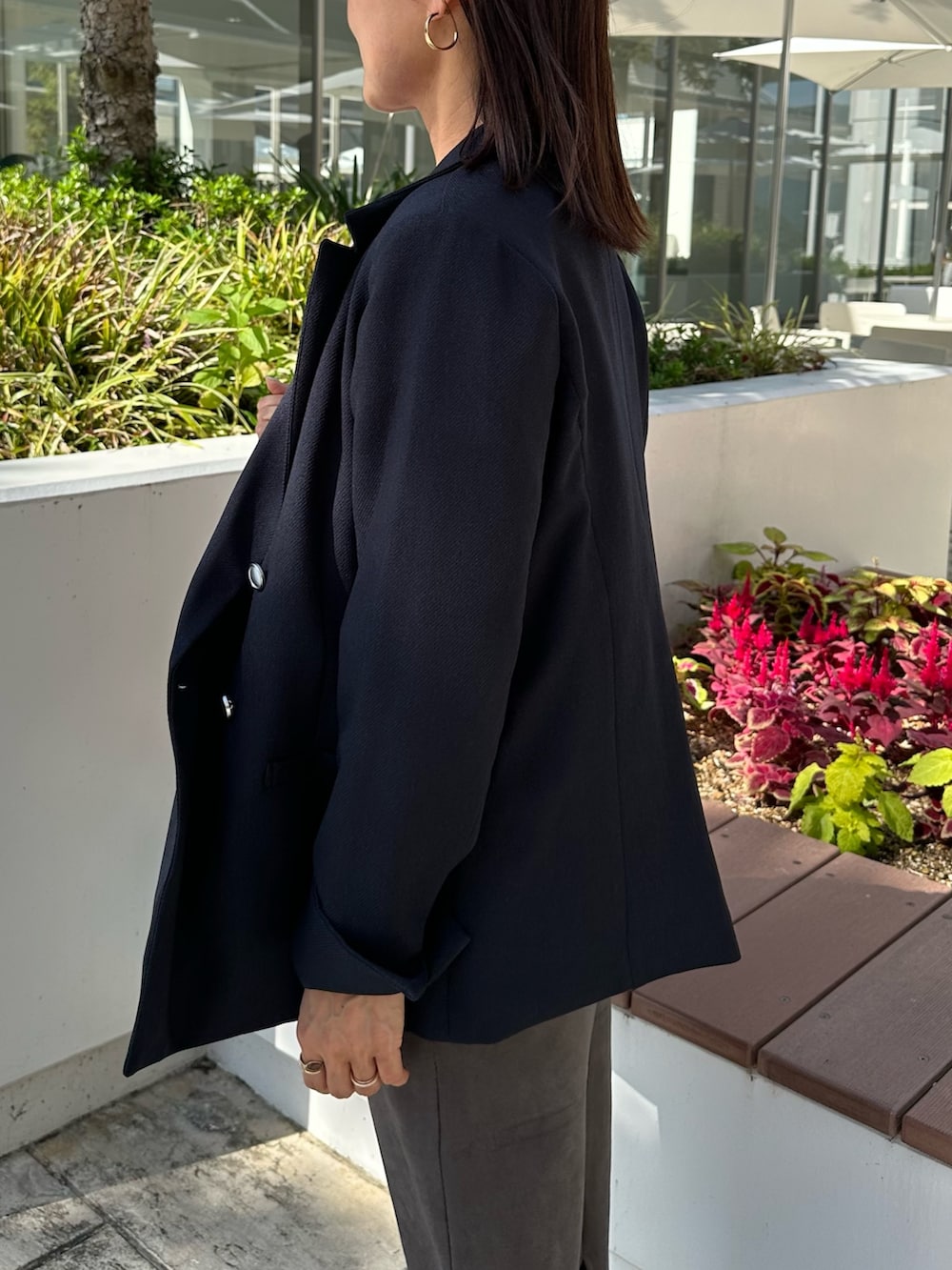 ブルー系のテーラードジャケット、ブルー系のニット/セーター、グレー系のスカートを着用したレディースの秋コーディネートの4枚目の写真