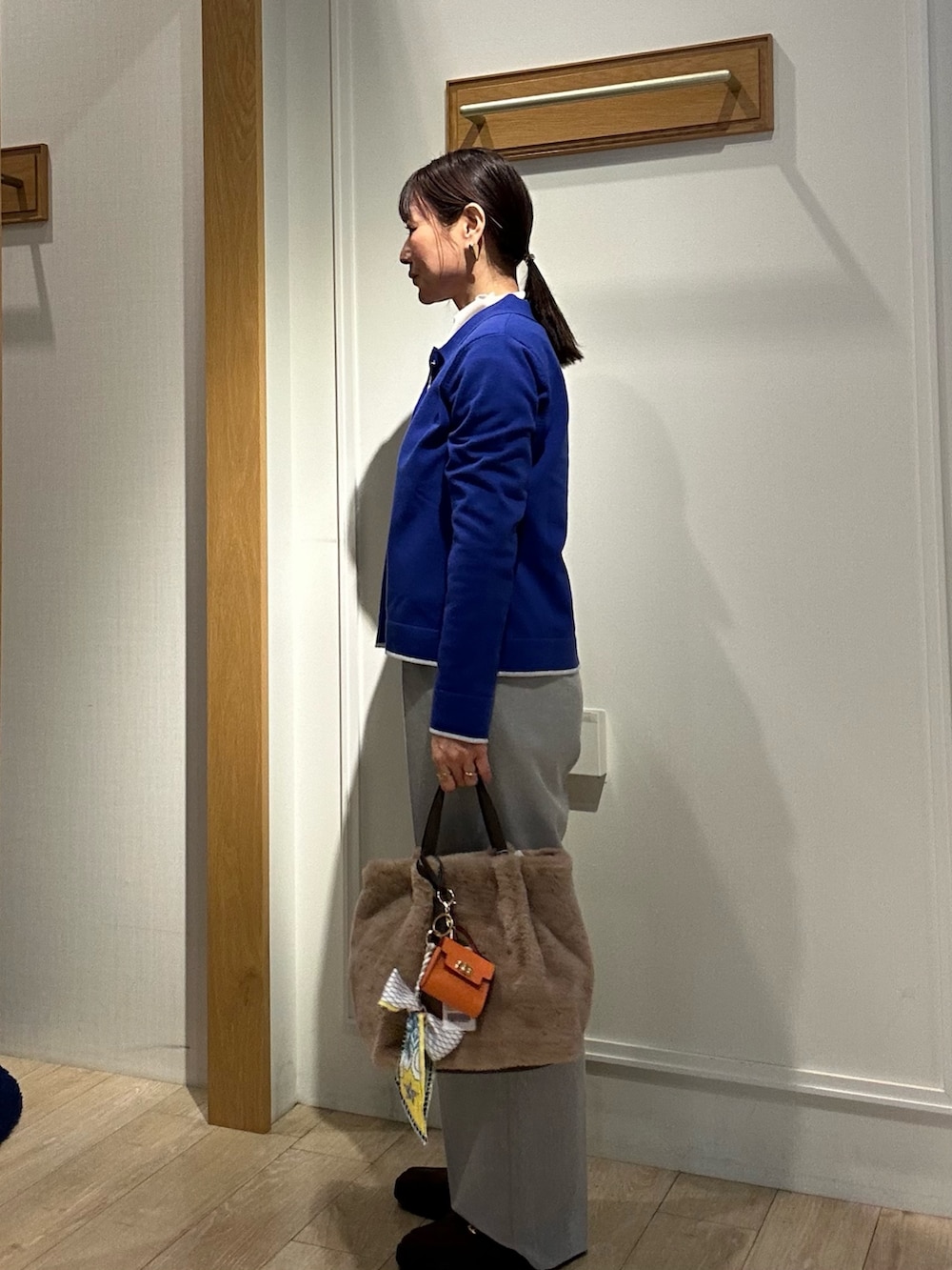 ブラウン系のローファー、ブラック系のダウンジャケット/コート、ブルー系のカーディガン/ボレロを着用したレディースの冬コーディネートの6枚目の写真