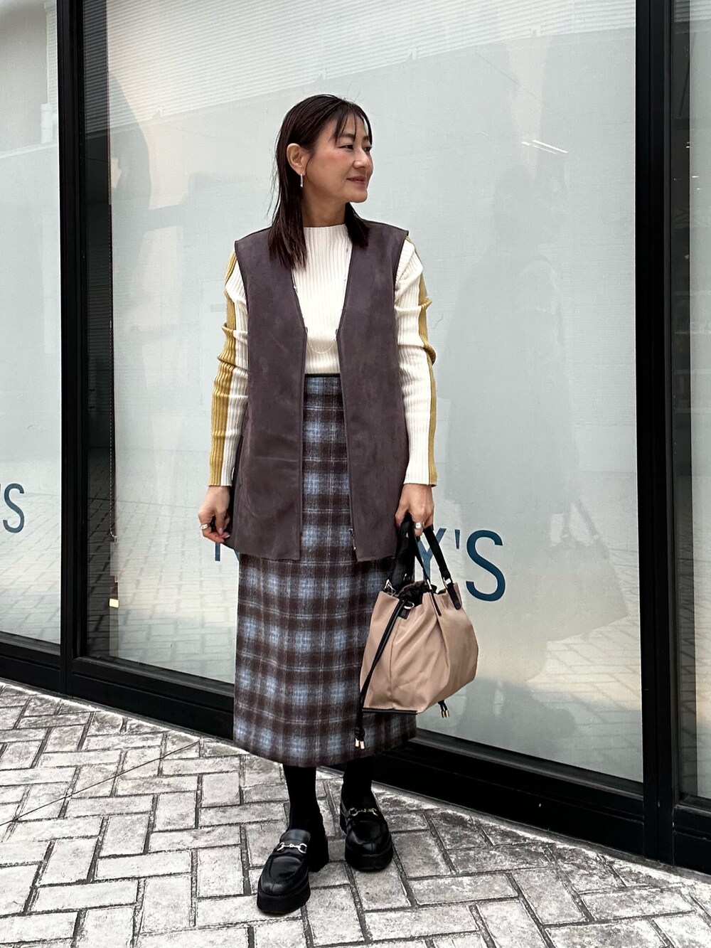 グレー系のブルゾン、グレー系のその他パンツ、ホワイト系のニット/セーターを着用したレディースの冬コーディネートの7枚目の写真