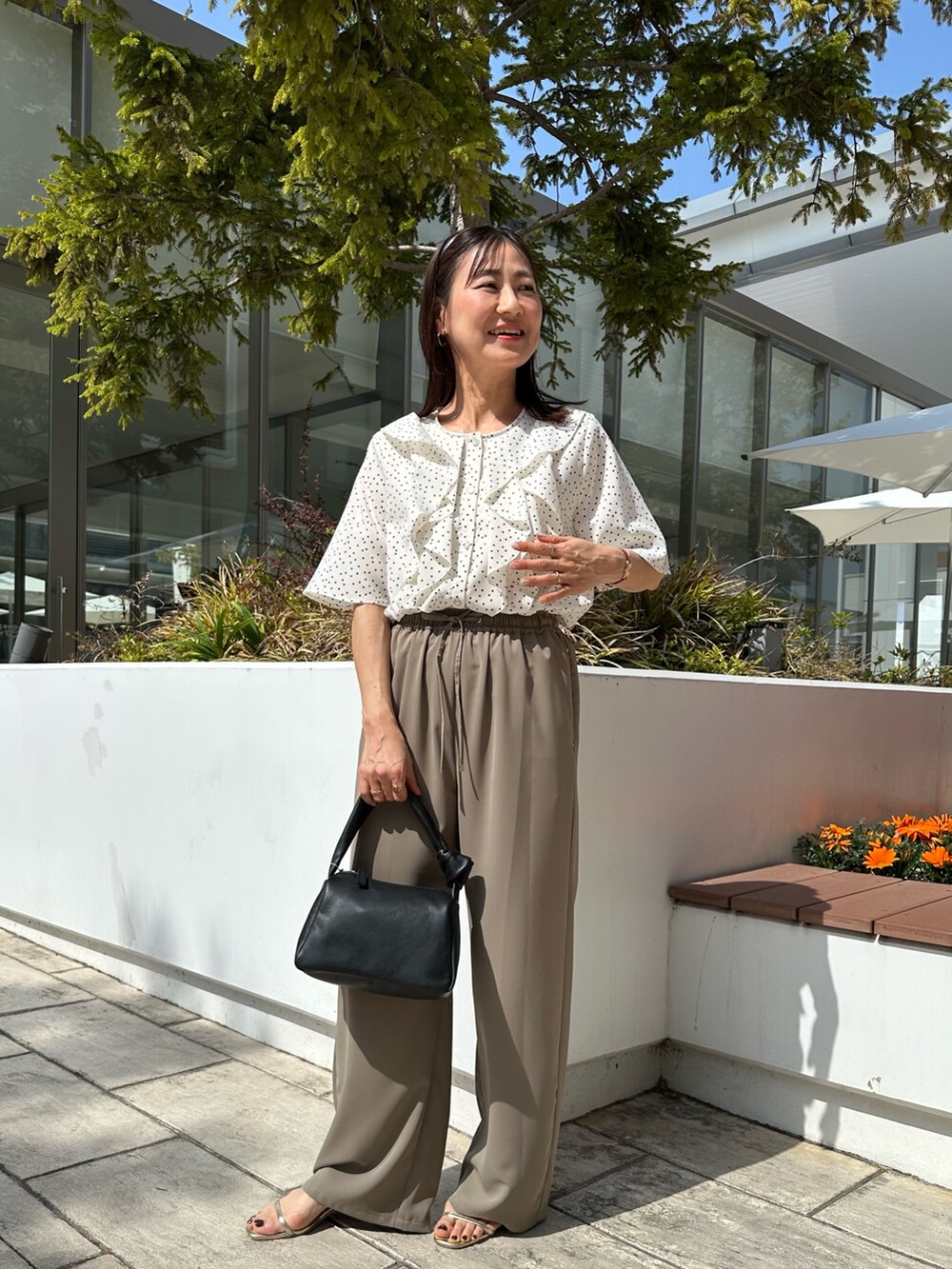 ホワイト系のシャツ/ブラウス、グリーン系のその他パンツ、ブラック系のショルダーバッグを着用したレディースの春コーディネートの4枚目の写真