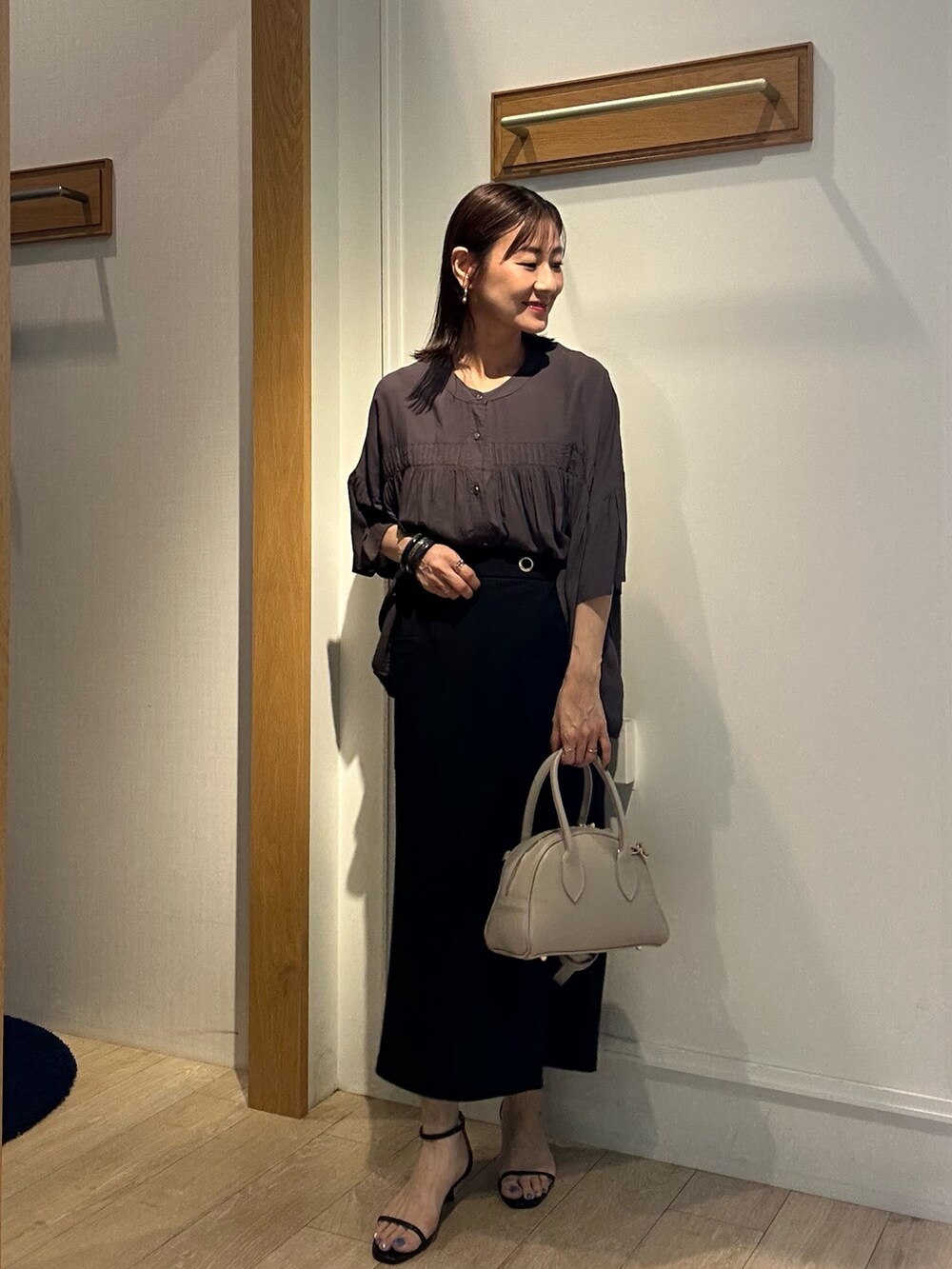 グレー系のシャツ/ブラウス、ブラック系のスカート、ベージュ系のボストンバッグを着用したレディースの夏コーディネートの2枚目の写真