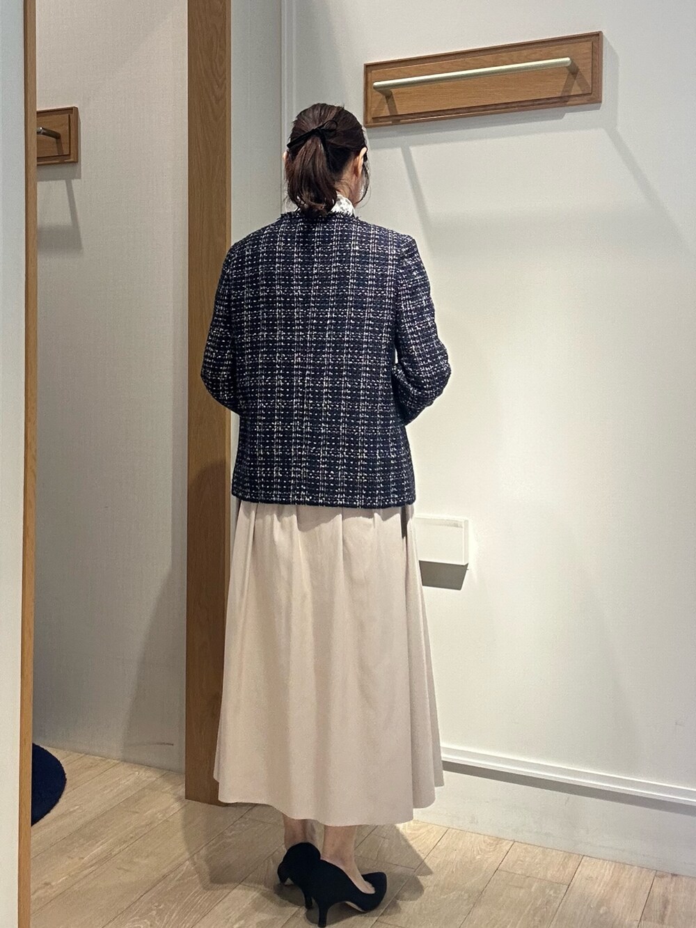 ブルー系のノーカラージャケット、ホワイト系のTシャツ/カットソー、ベージュ系のスカートを着用したレディースの冬コーディネートの3枚目の写真