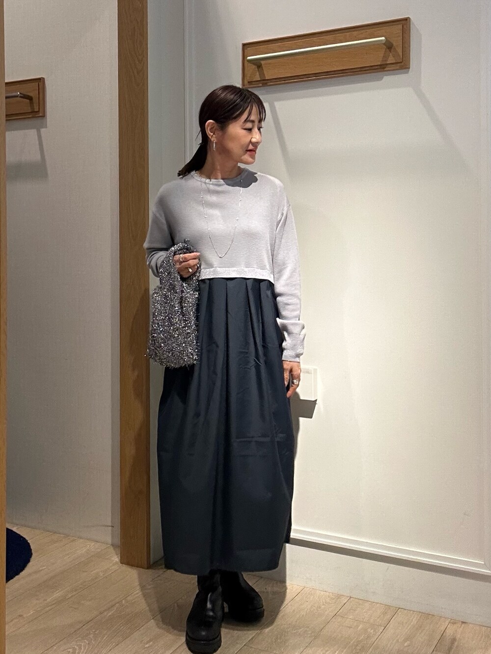 ベージュ系のブルゾン、グレー系のワンピースを着用したレディースの冬コーディネートの7枚目の写真