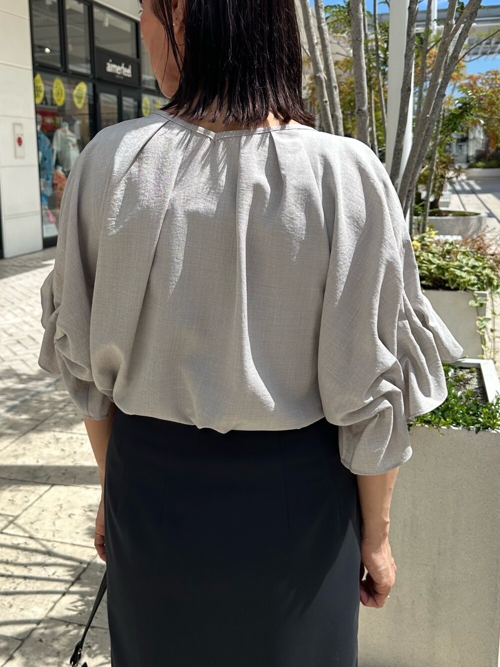 ブラック系のサンダル、ベージュ系のシャツ/ブラウス、ブルー系のスカートを着用したレディースの夏コーディネートの6枚目の写真