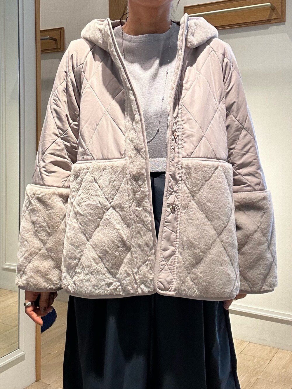 ベージュ系のブルゾン、グレー系のワンピースを着用したレディースの冬コーディネートの4枚目の写真