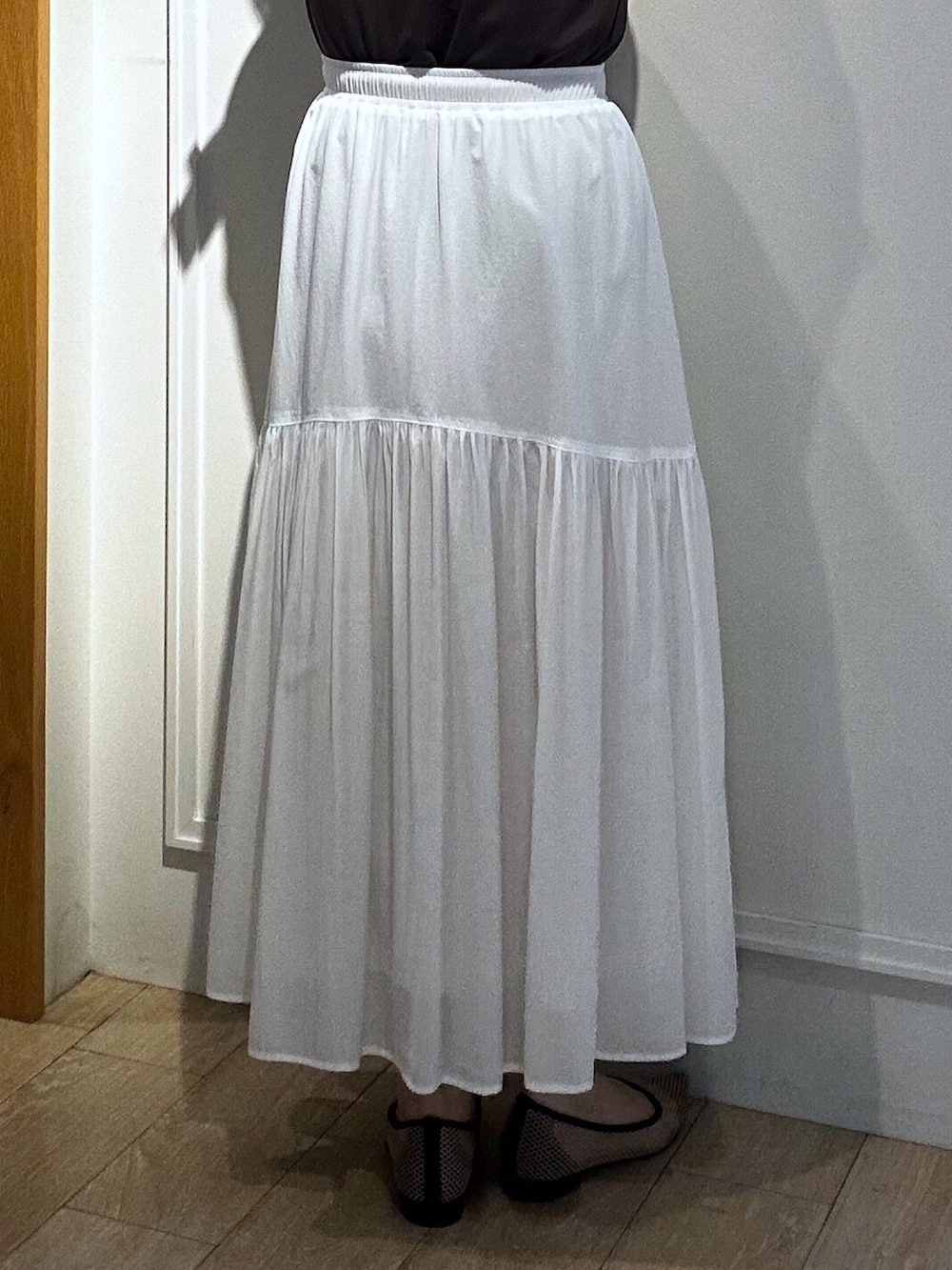 イエロー系のブルゾン、ブラウン系のTシャツ/カットソー、ホワイト系のスカートを着用したレディースの春コーディネートの8枚目の写真