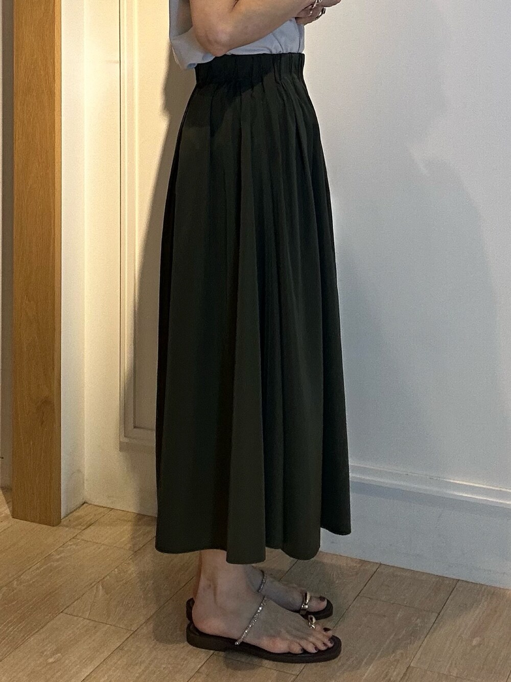 グリーン系のスカート、グレー系のTシャツ/カットソーを着用したレディースの春コーディネートの9枚目の写真