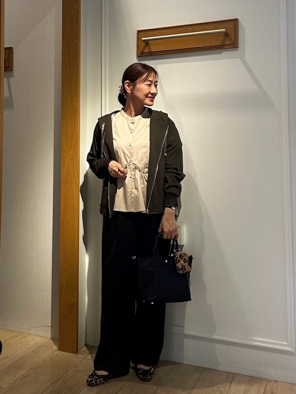 グリーン系のブルゾン、ベージュ系のTシャツ/カットソー、ブラック系のトートバッグを着用したレディースの秋コーディネートの8枚目の写真