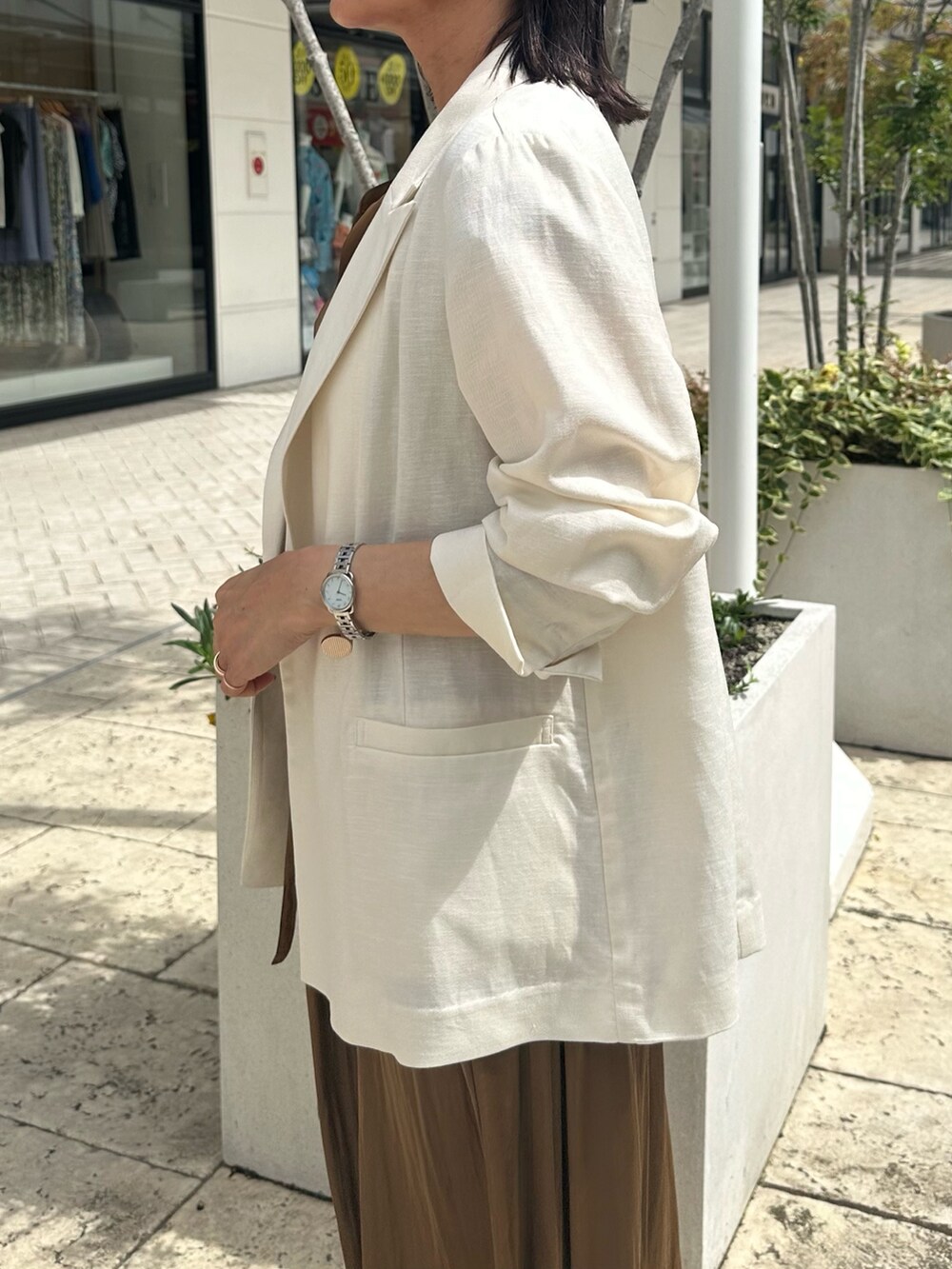 ブラウン系のワンピース、グレー系のTシャツ/カットソー、ホワイト系のテーラードジャケットを着用したレディースの夏コーディネートの8枚目の写真