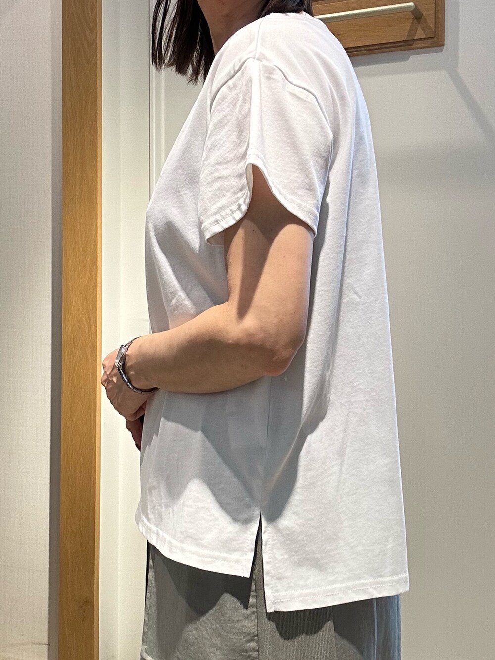 グリーン系のスカート、ホワイト系のTシャツ/カットソー、ブラック系のボストンバッグを着用したレディースの夏コーディネートの4枚目の写真