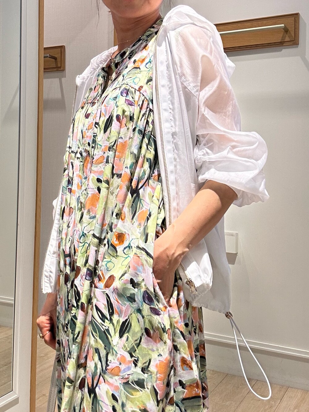 ホワイト系のブルゾン、グリーン系のワンピースを着用したレディースの夏コーディネートの5枚目の写真