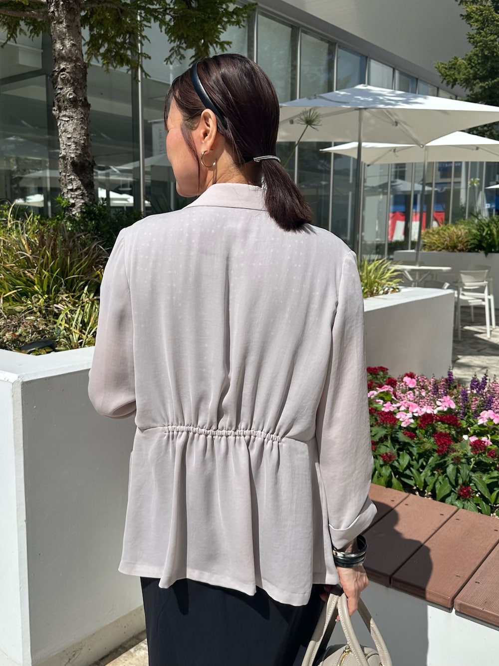 ベージュ系のテーラードジャケット、ブラック系のシャツ/ブラウス、ベージュ系のボストンバッグを着用したレディースの夏コーディネートの6枚目の写真