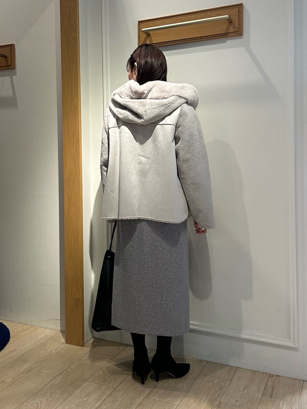 ベージュ系のムートンコート、ブルー系のニット/セーター、ホワイト系のニット/セーターを着用したレディースの冬コーディネートの4枚目の写真