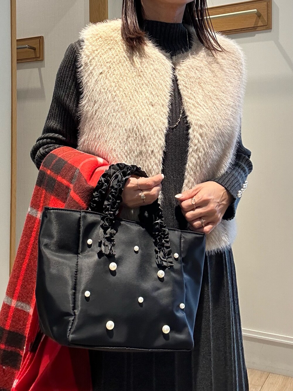 ベージュ系のブルゾン、グレー系のワンピース、ブラック系のダウンジャケット/コートを着用したレディースの冬コーディネートの4枚目の写真