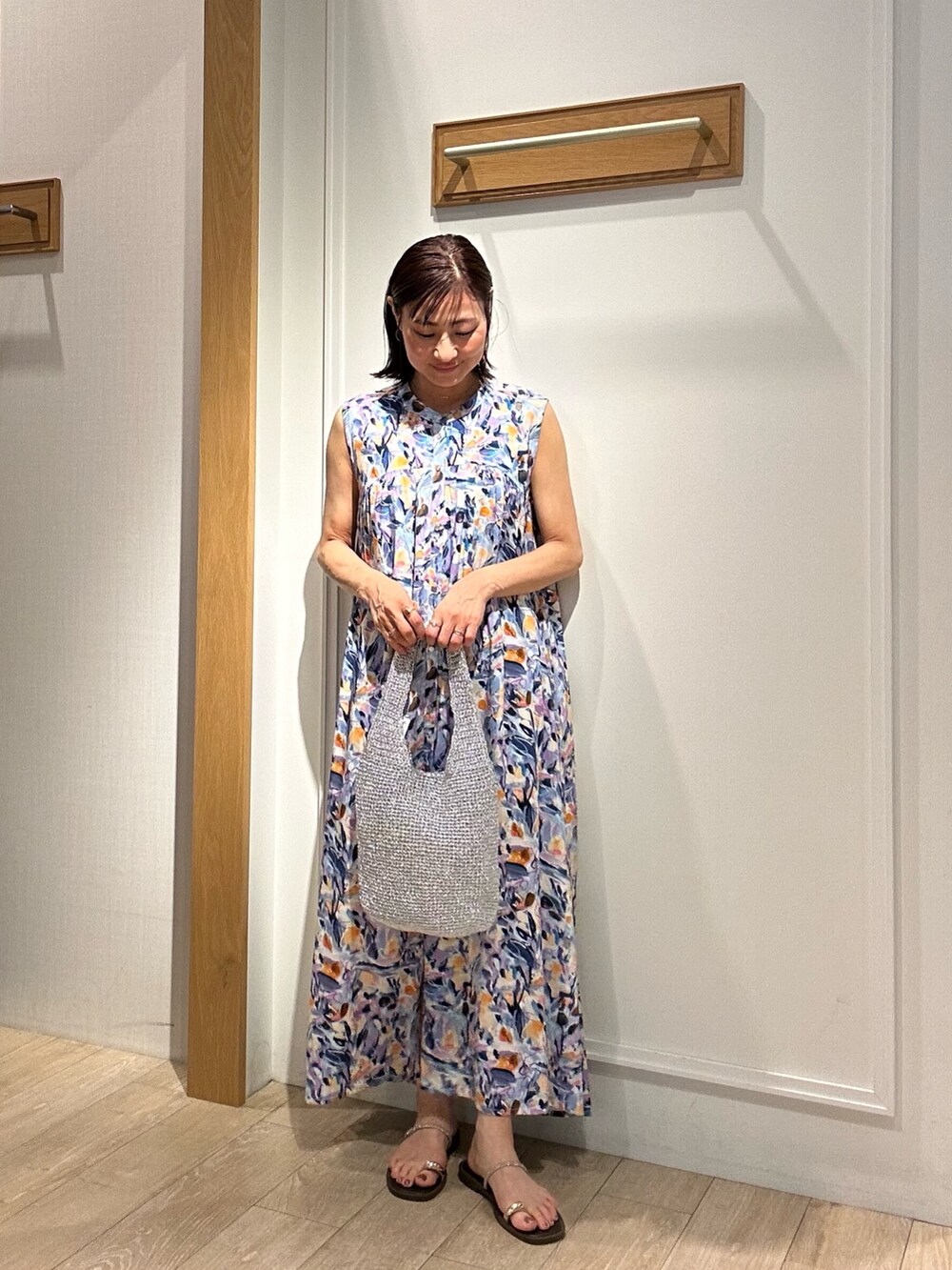 ブルー系のワンピース、グレー系のニット/セーター、ブラウン系のサンダルを着用したレディースの夏コーディネートの3枚目の写真