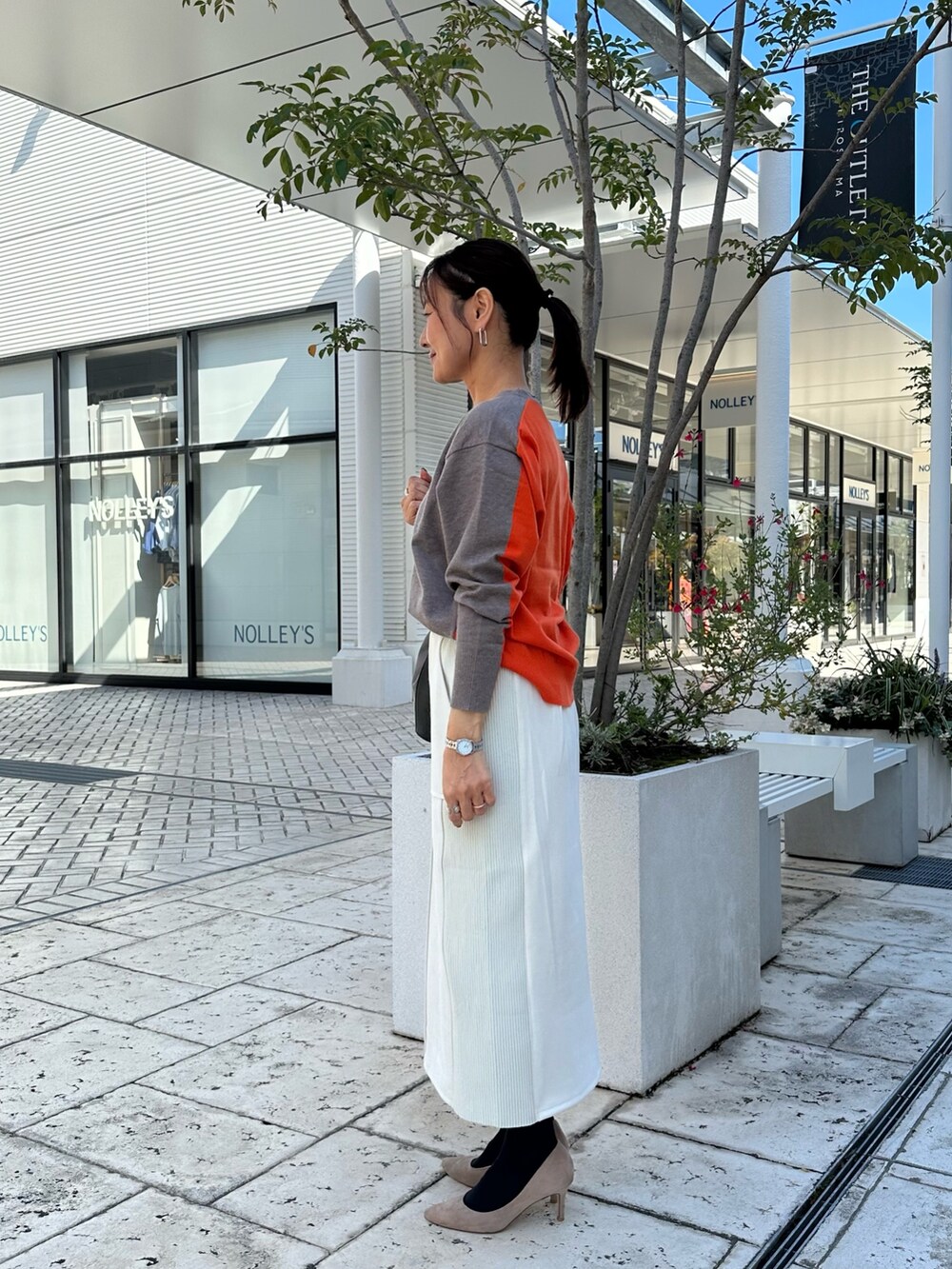 ブラウン系のニット/セーター、グレー系のスカート、ブラウン系のブルゾンを着用したレディースの秋コーディネートの2枚目の写真