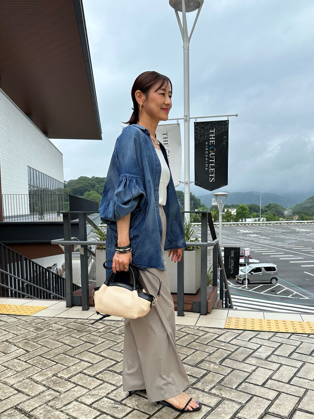 ホワイト系のTシャツ/カットソー、ベージュ系のその他パンツ、ブラック系のバックパック/リュックを着用したレディースの夏コーディネートの5枚目の写真