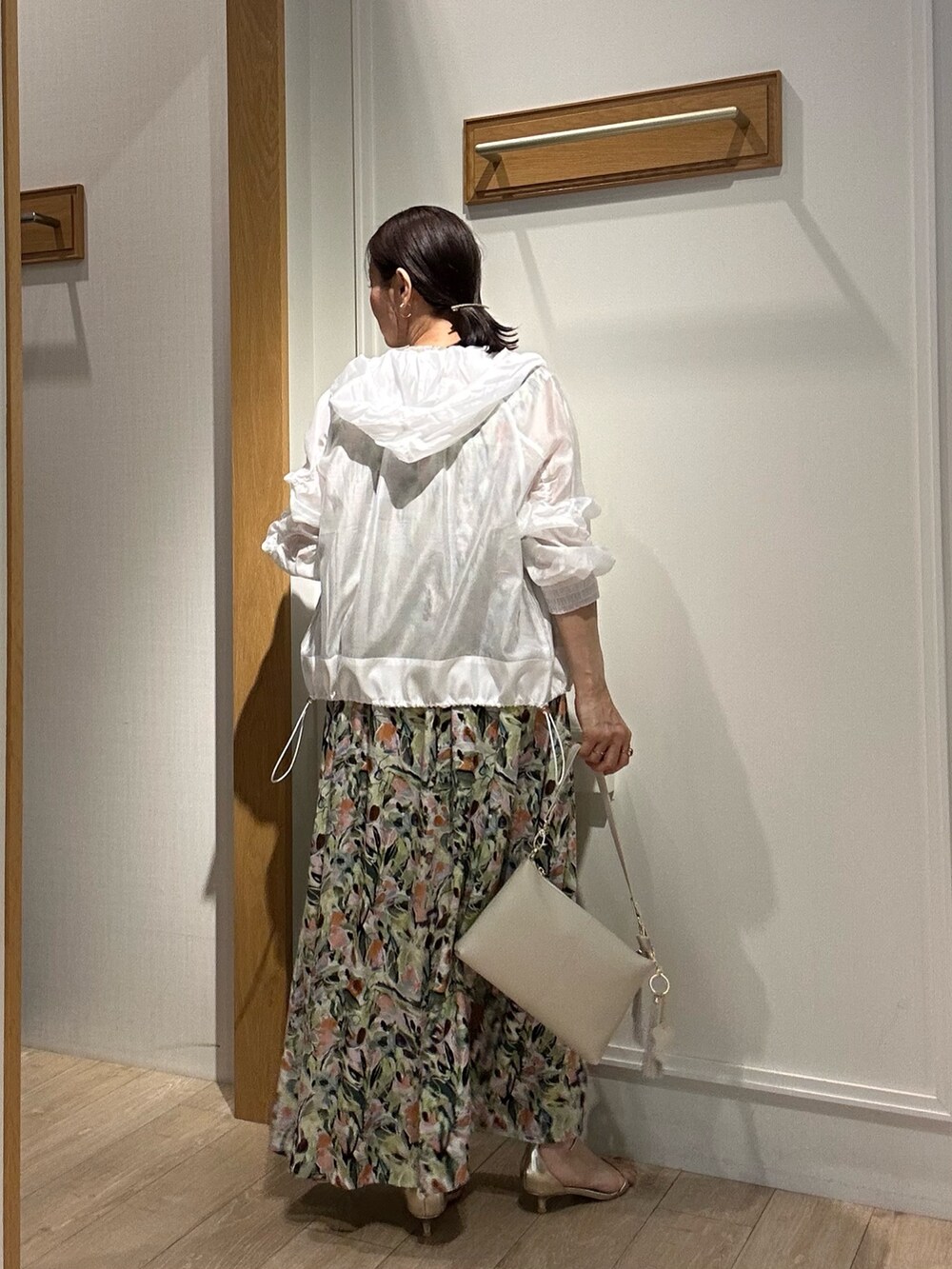 ホワイト系のブルゾン、グリーン系のワンピースを着用したレディースの夏コーディネートの3枚目の写真