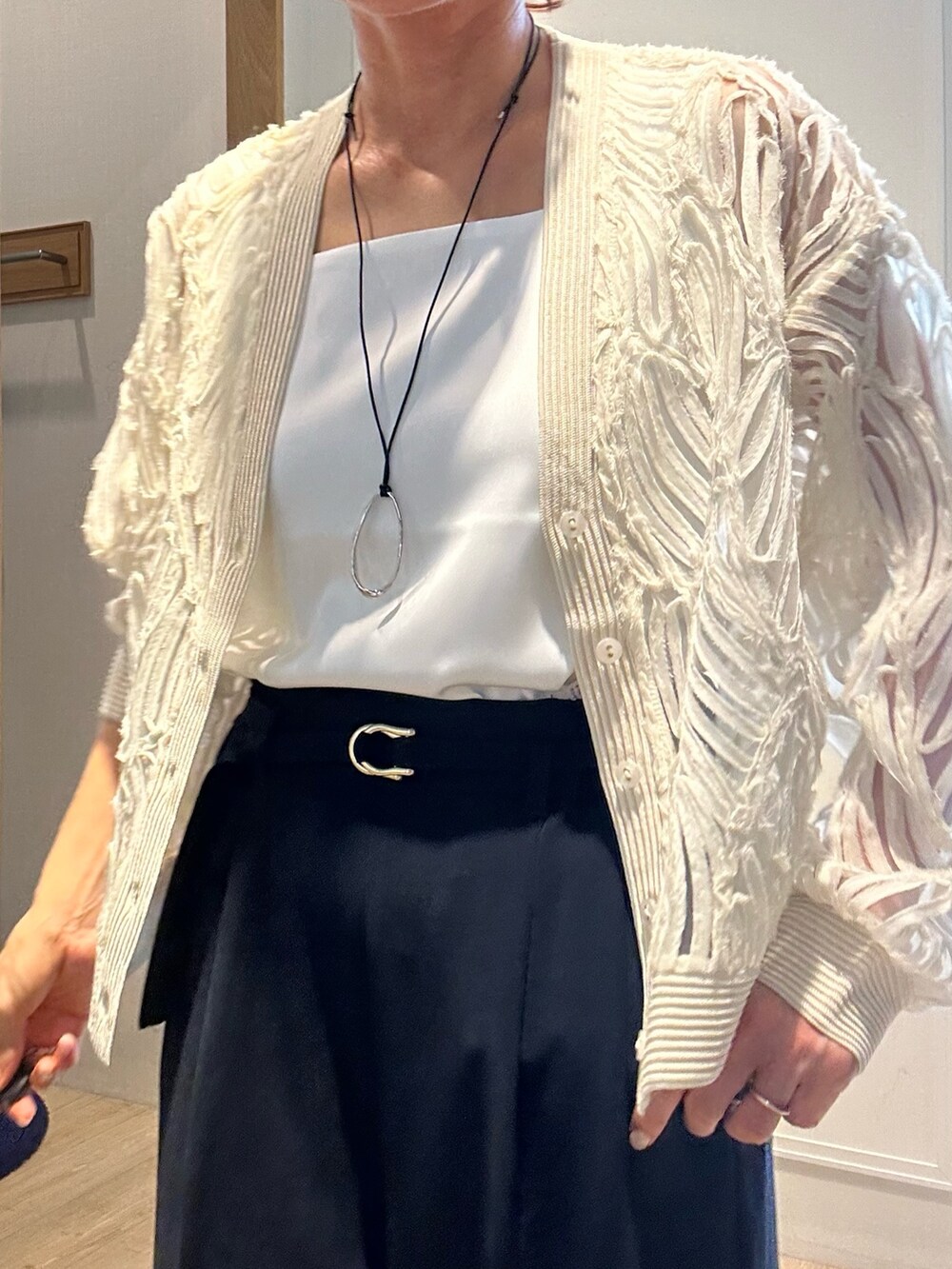 ホワイト系のカーディガン/ボレロ、シルバー系のネックレスを着用したレディースの冬コーディネートの4枚目の写真