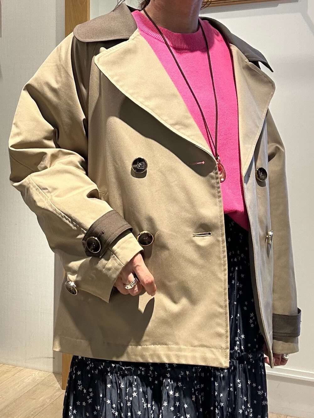 イエロー系のトレンチコート、ピンク系のニット/セーターを着用したレディースの秋コーディネートの8枚目の写真