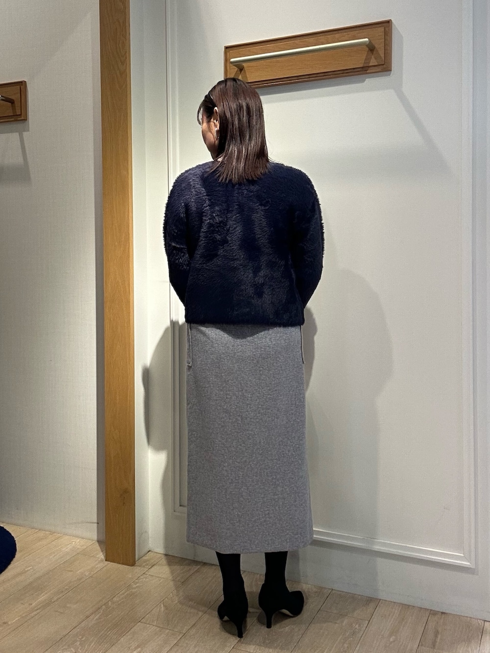 ベージュ系のムートンコート、ブルー系のニット/セーター、ホワイト系のニット/セーターを着用したレディースの冬コーディネートの9枚目の写真