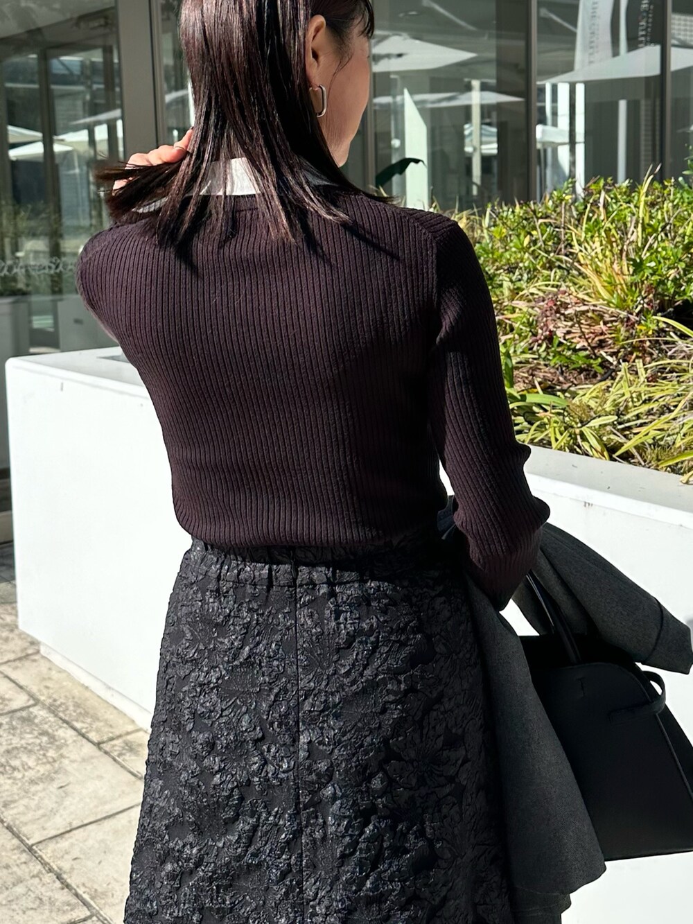 ブラック系のトートバッグ、グレー系のテーラードジャケット、ブラック系のニット/セーターを着用したレディースの秋コーディネートの6枚目の写真