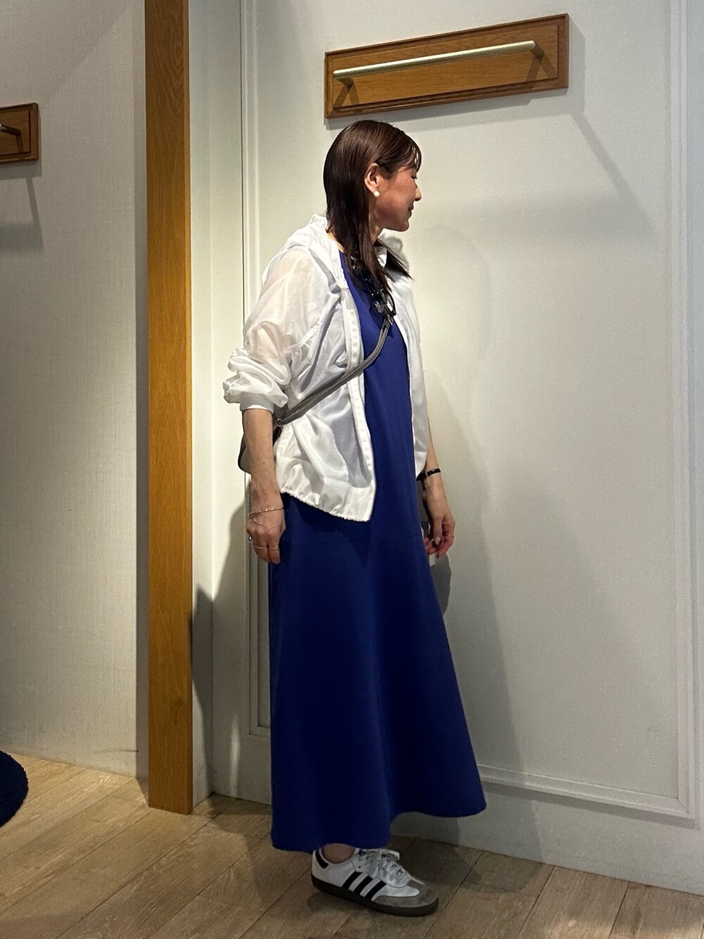 ホワイト系のブルゾン、グレー系のショルダーバッグを着用したレディースの春コーディネートの4枚目の写真
