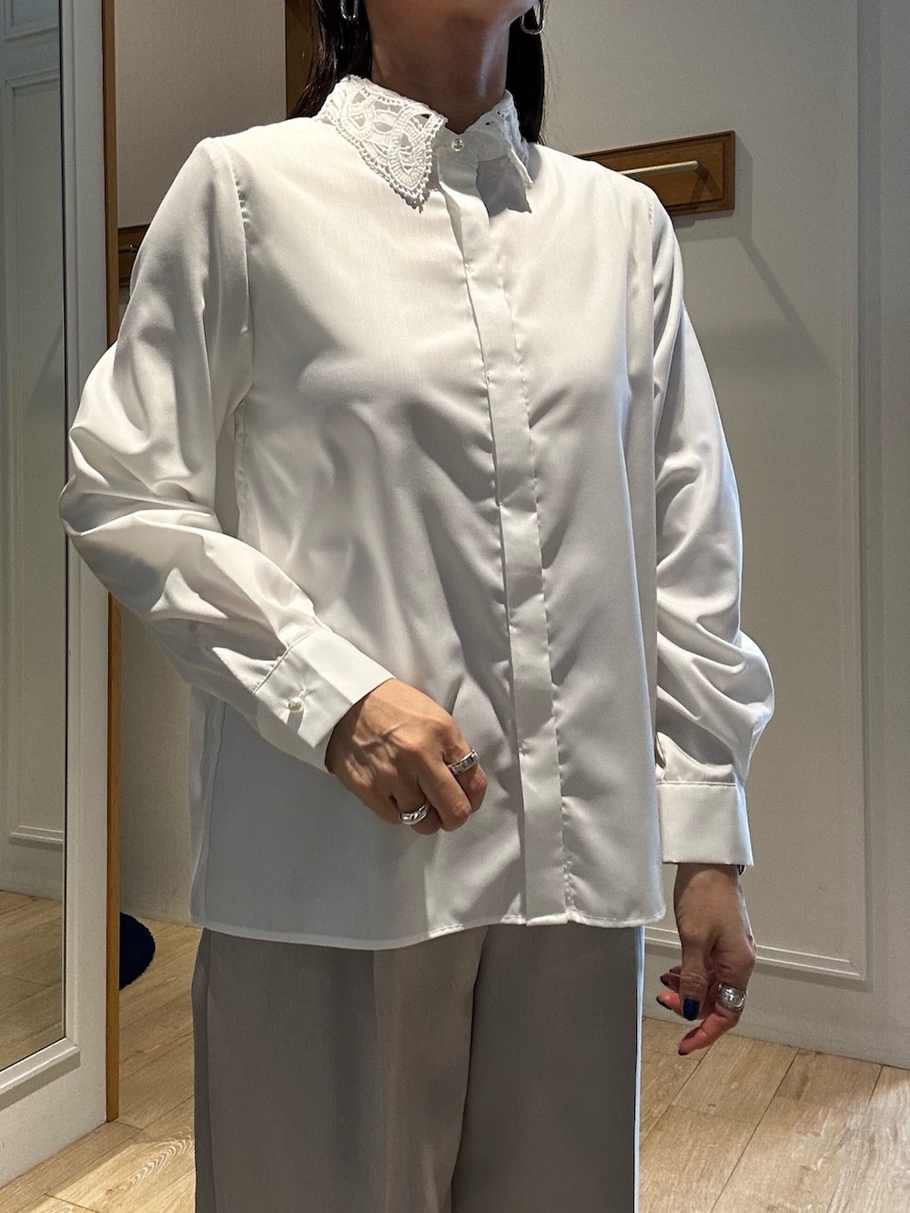 ブラック系のニット/セーター、ブラック系のショルダーバッグ、ホワイト系のシャツ/ブラウスを着用したレディースの冬コーディネートの10枚目の写真