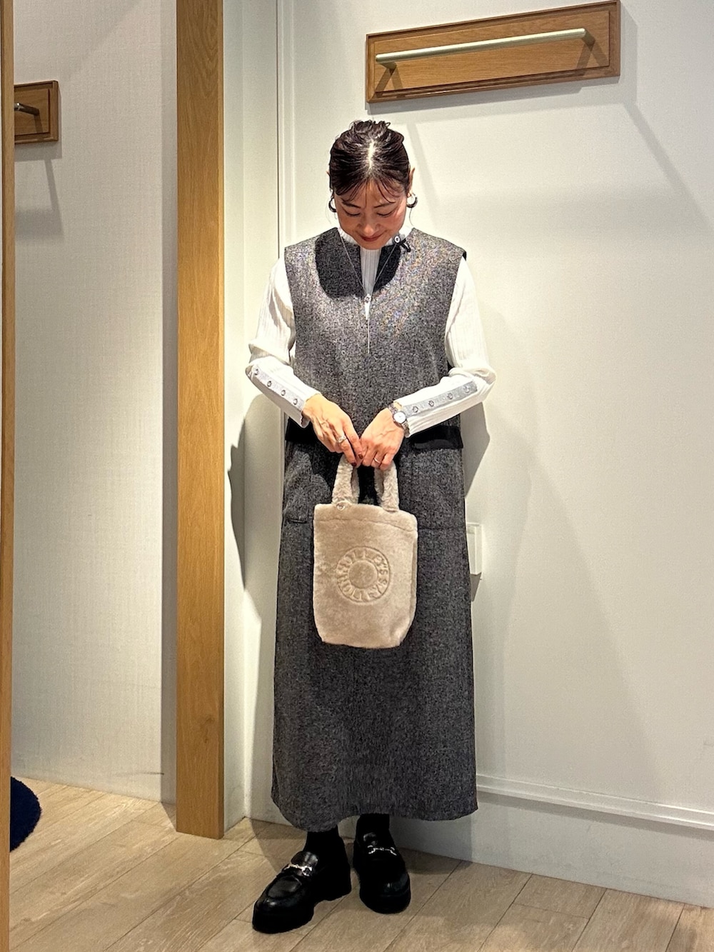 グレー系のワンピース、ホワイト系のニット/セーター、ベージュ系のトートバッグを着用したレディースの秋コーディネートの4枚目の写真