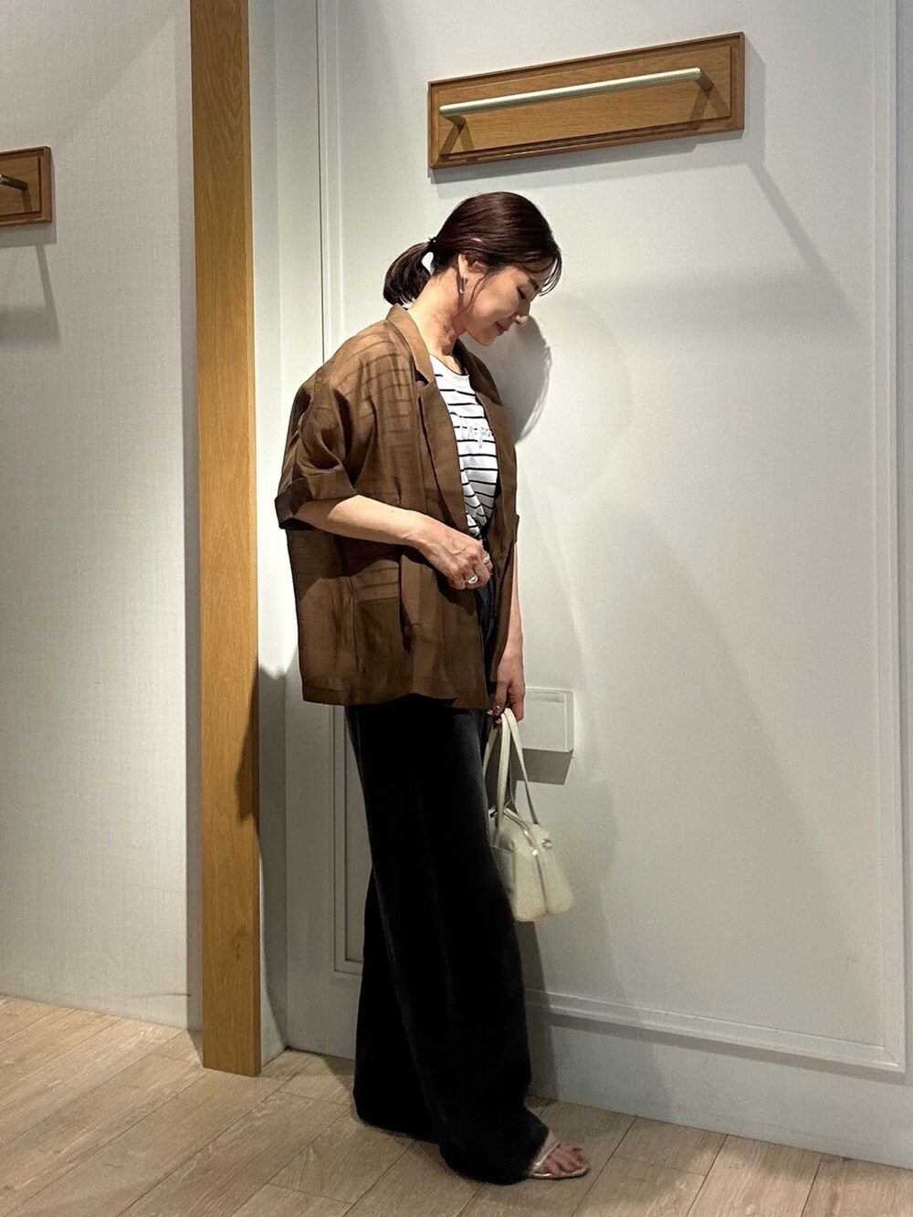 ホワイト系のTシャツ/カットソー、ホワイト系のボストンバッグ、ブラウン系のテーラードジャケットを着用したレディースの夏コーディネートの2枚目の写真