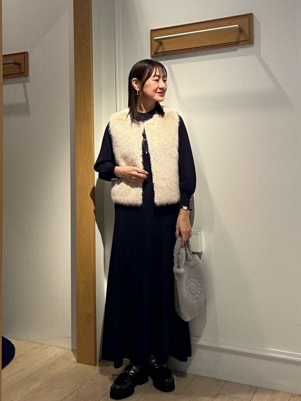 ブルー系のワンピース、グレー系のトートバッグ、ベージュ系のブルゾンを着用したレディースの秋コーディネートの6枚目の写真