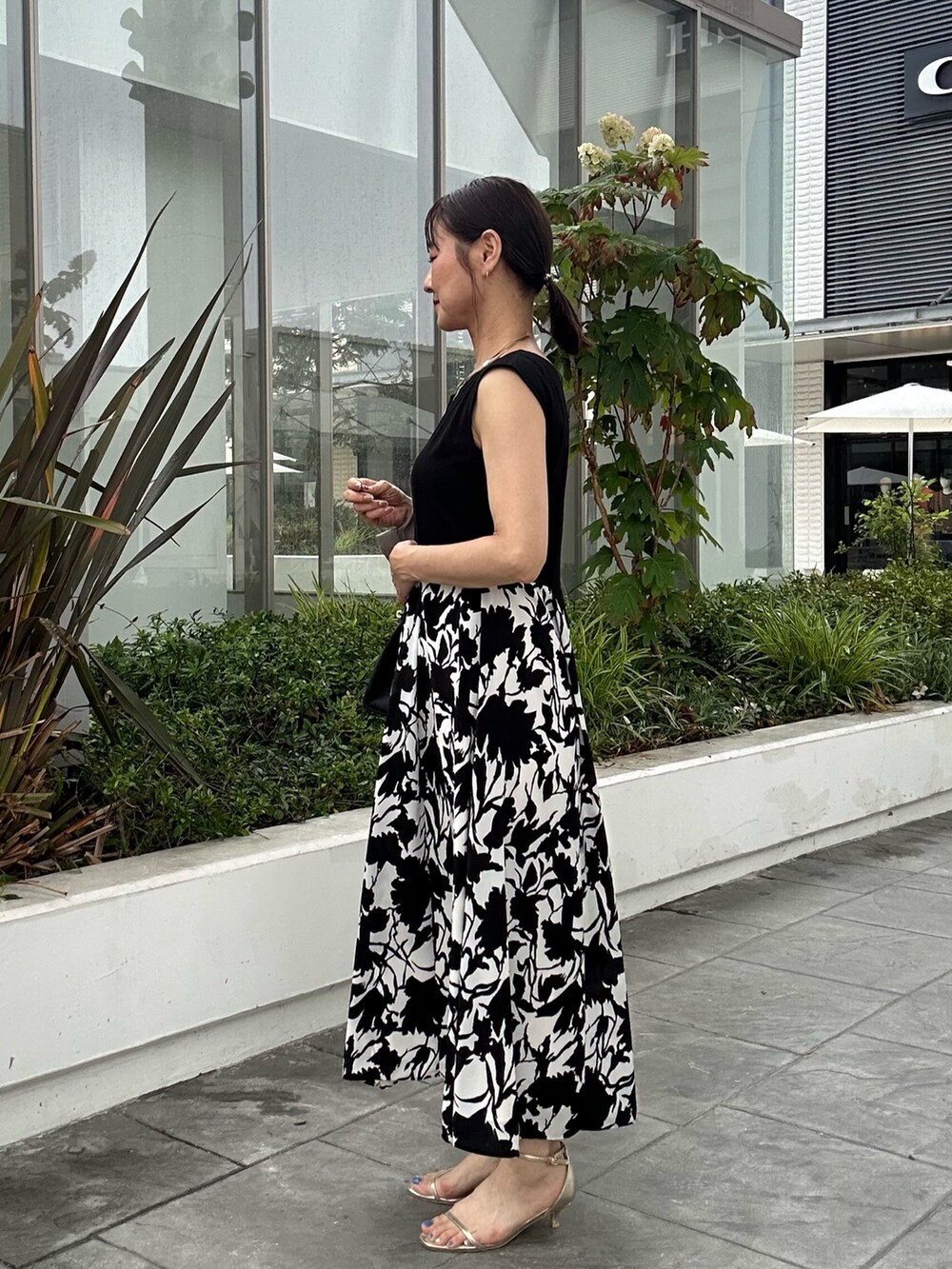 ホワイト系のワンピース、ブラック系のショルダーバッグ、ベージュ系のテーラードジャケットを着用したレディースの夏コーディネートの2枚目の写真