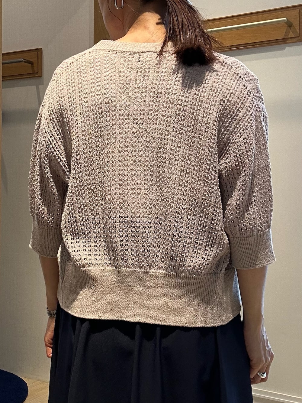 ベージュ系のニット/セーター、ホワイト系のTシャツ/カットソー、ブルー系のスカートを着用したレディースの春コーディネートの6枚目の写真