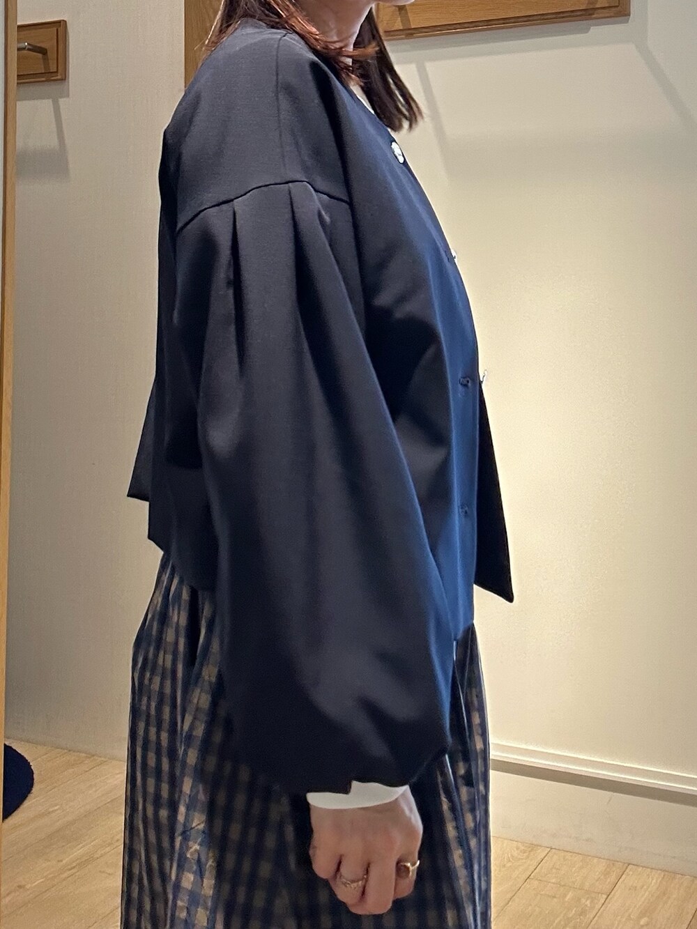 ブルー系のノーカラージャケット、ホワイト系のTシャツ/カットソー、ブラウン系のスカートを着用したレディースの冬コーディネートの6枚目の写真