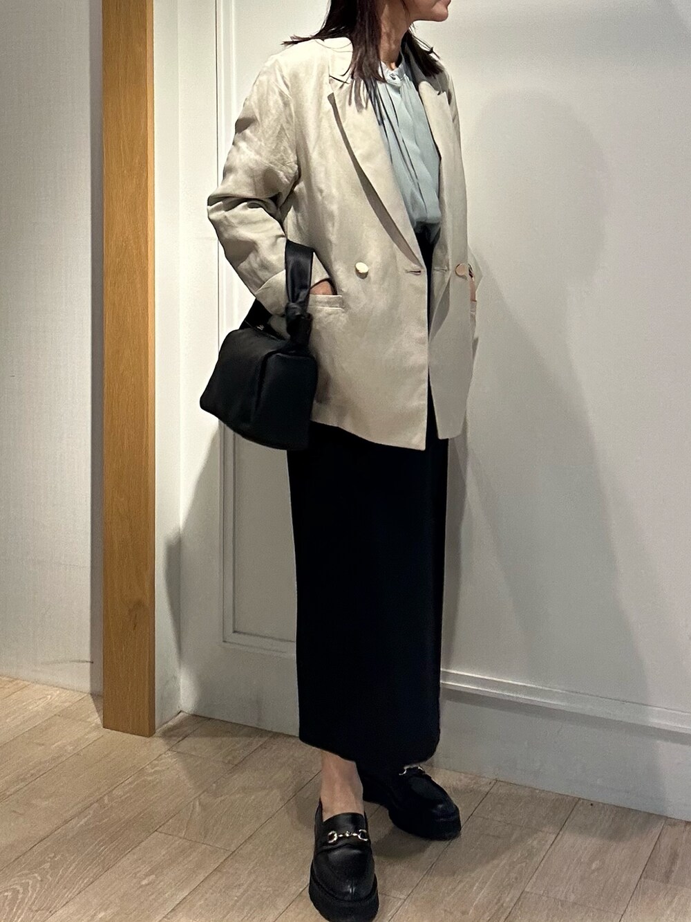 ベージュ系のテーラードジャケット、グリーン系のシャツ/ブラウス、ブラック系のスカートを着用したレディースの春コーディネートの4枚目の写真