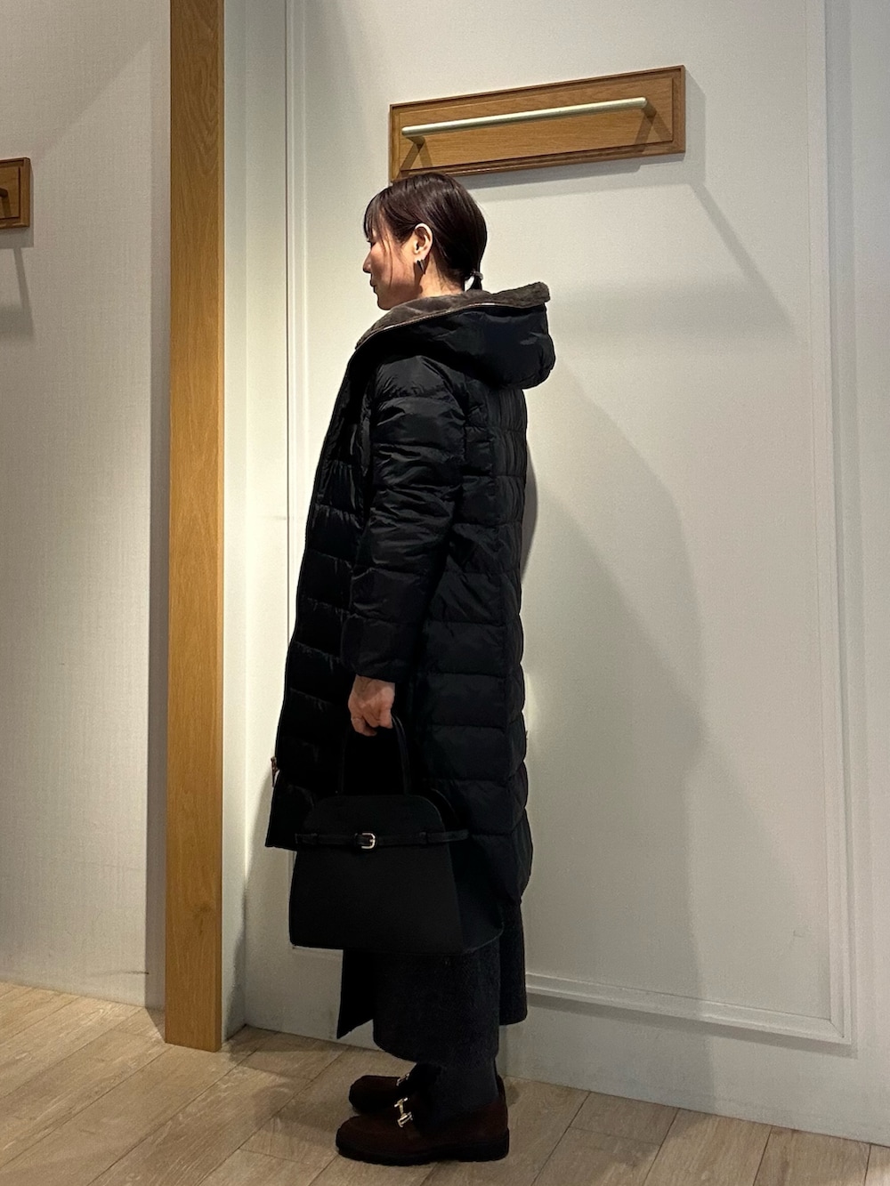 ブラック系のダウンジャケット/コート、グレー系のスカート、ブラック系のトートバッグを着用したレディースの冬コーディネートの5枚目の写真