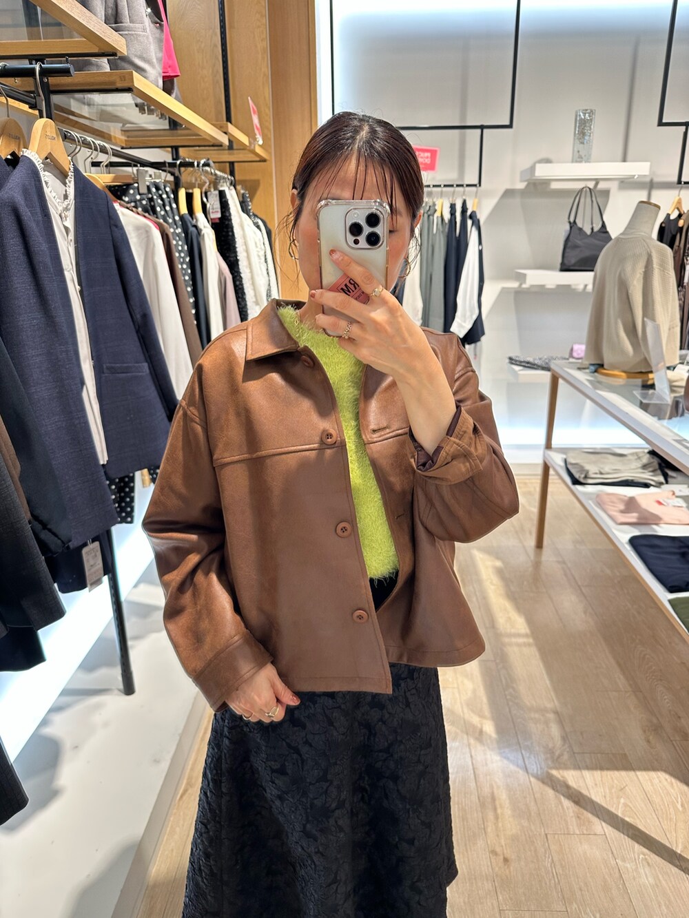 イエロー系のブルゾン、グリーン系のニット/セーター、グレー系のスカートを着用したレディースの秋コーディネートの8枚目の写真