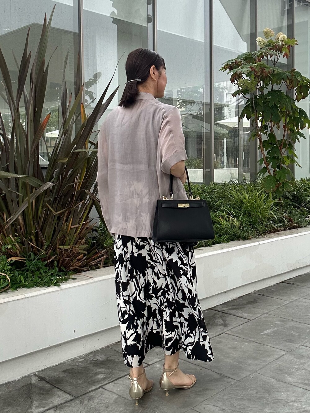 ホワイト系のワンピース、ブラック系のショルダーバッグ、ベージュ系のテーラードジャケットを着用したレディースの夏コーディネートの10枚目の写真
