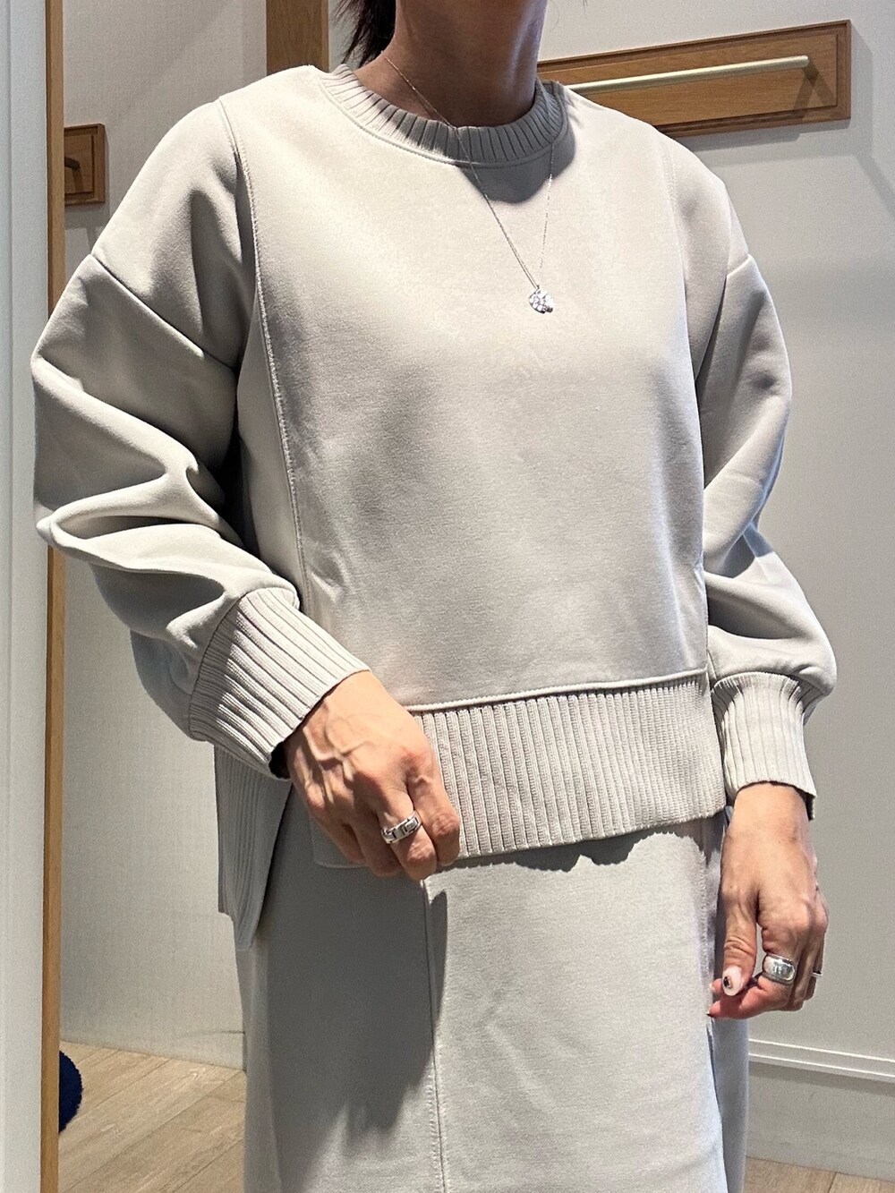 グレー系のトートバッグ、ベージュ系のスカート、ベージュ系のTシャツ/カットソーを着用したレディースの秋コーディネートの6枚目の写真